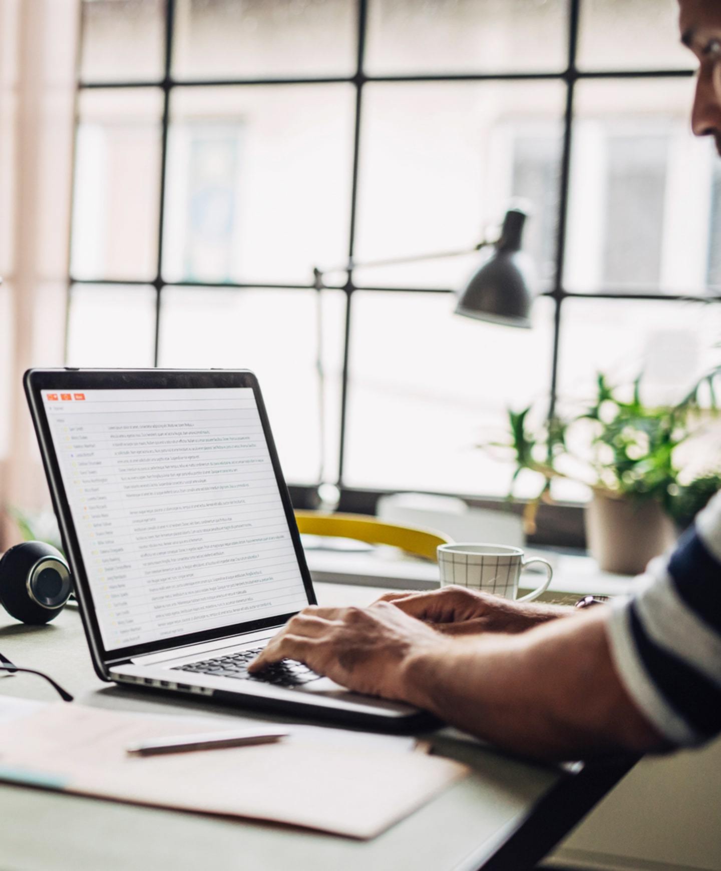 Hands resting on a laptop keyboard sitting on desk