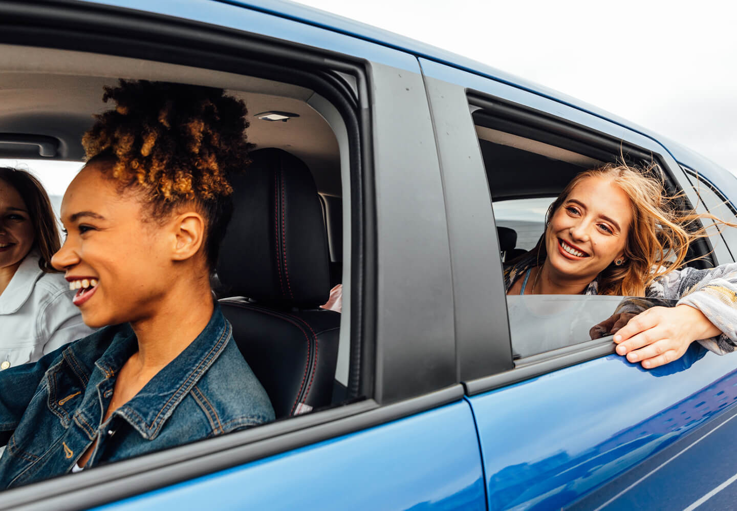 Three women in a blue car